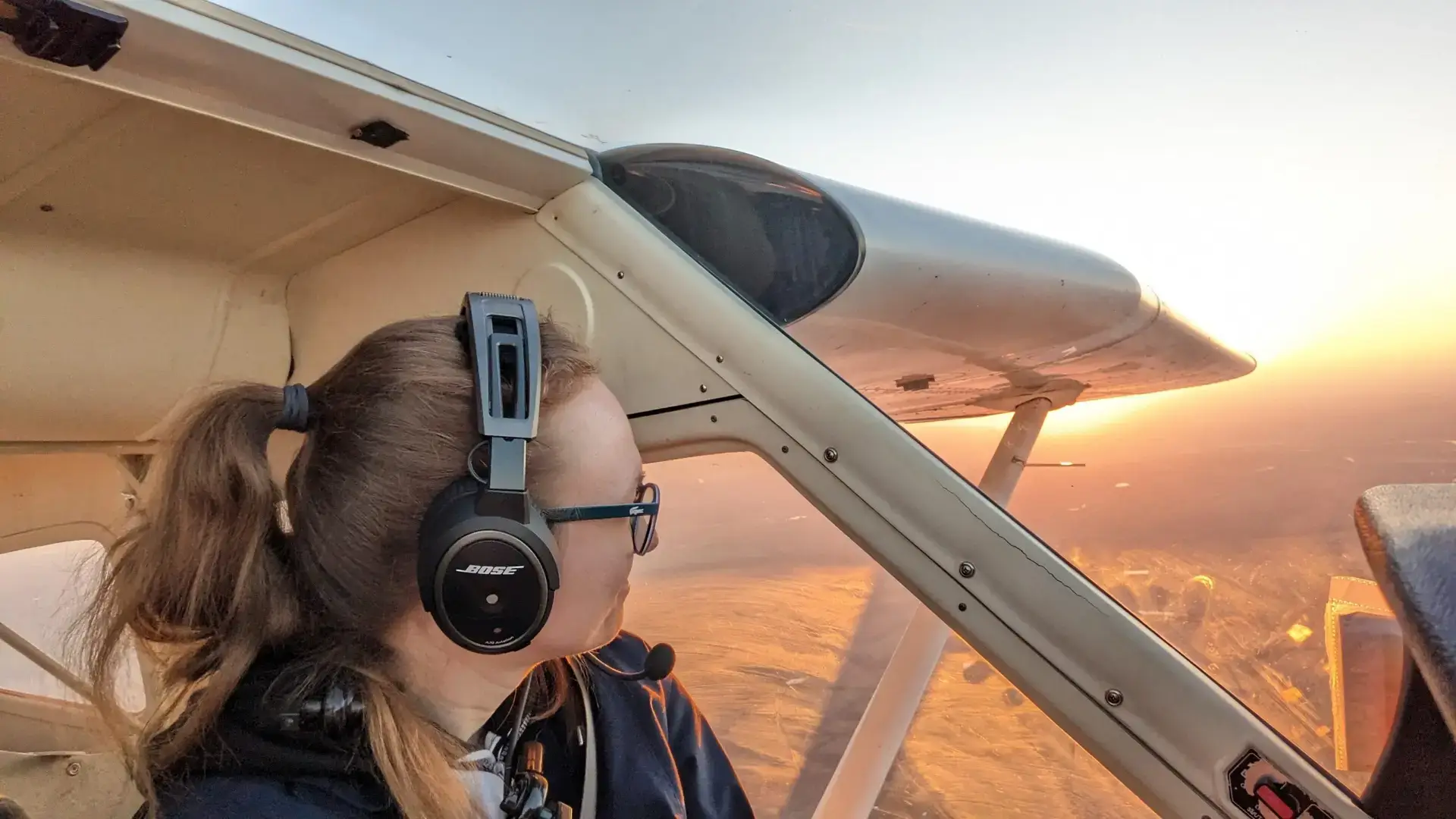 Woman pilot flying a plane in bright sunlight during Dayton Aviation Services flight training
